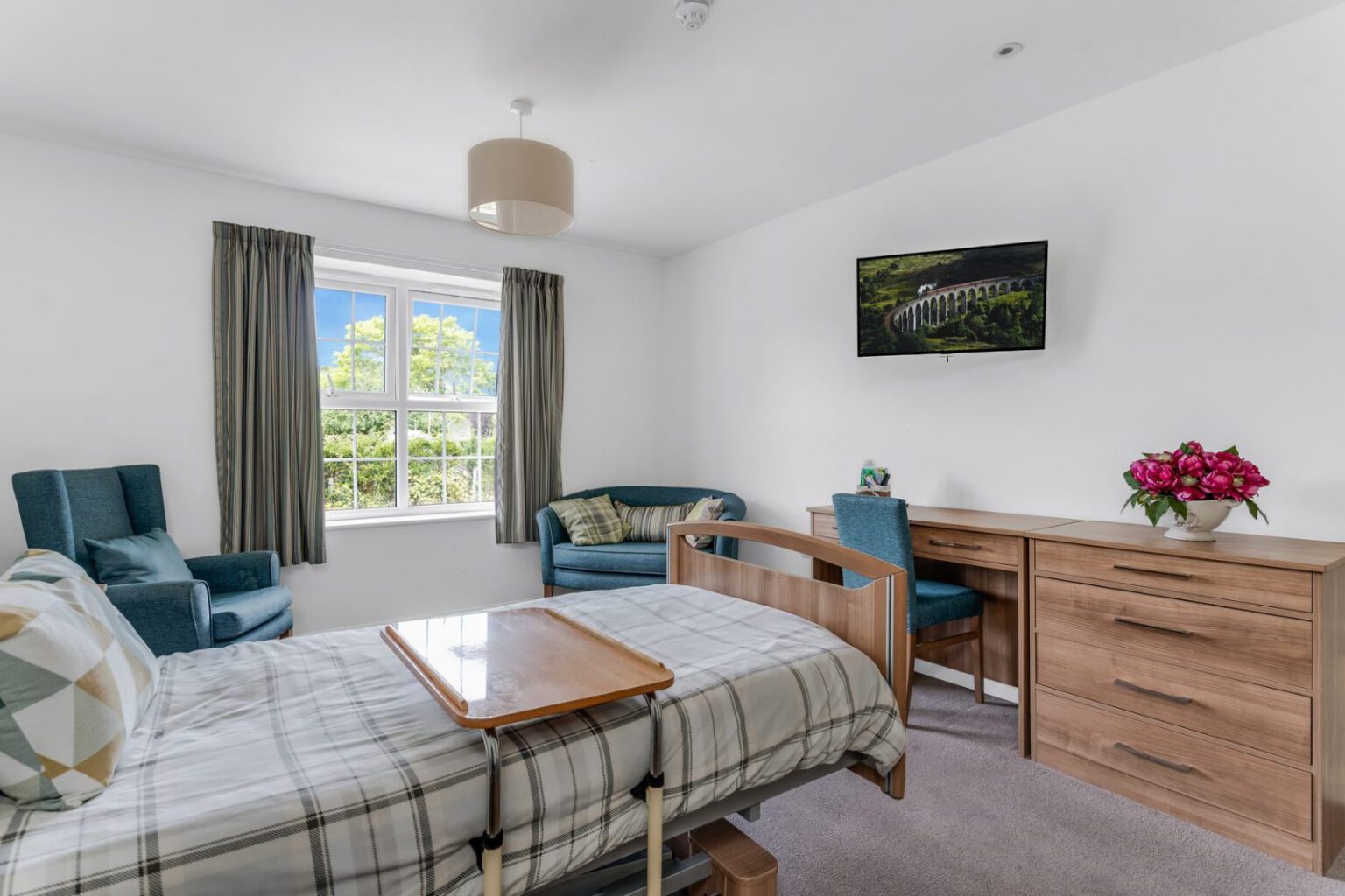 A bright bedroom at Downs House with a garden view